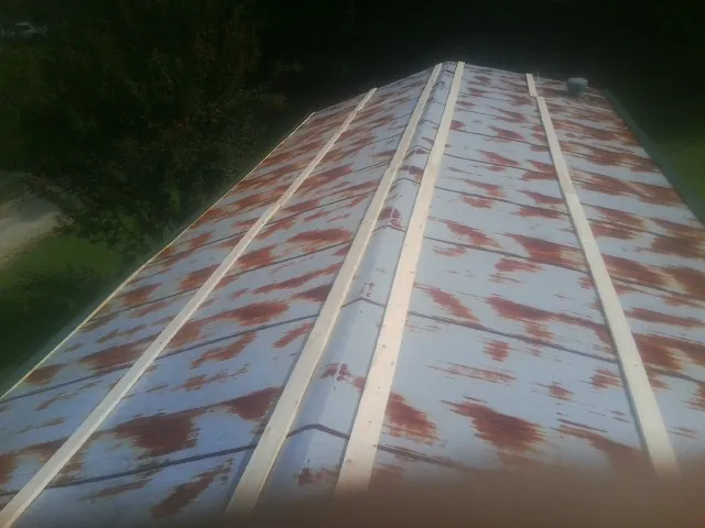 Rusted metal roof panels with new wood purlins before replacement — Storm Damage Roof Repair in Universal City by Roofing Brothers