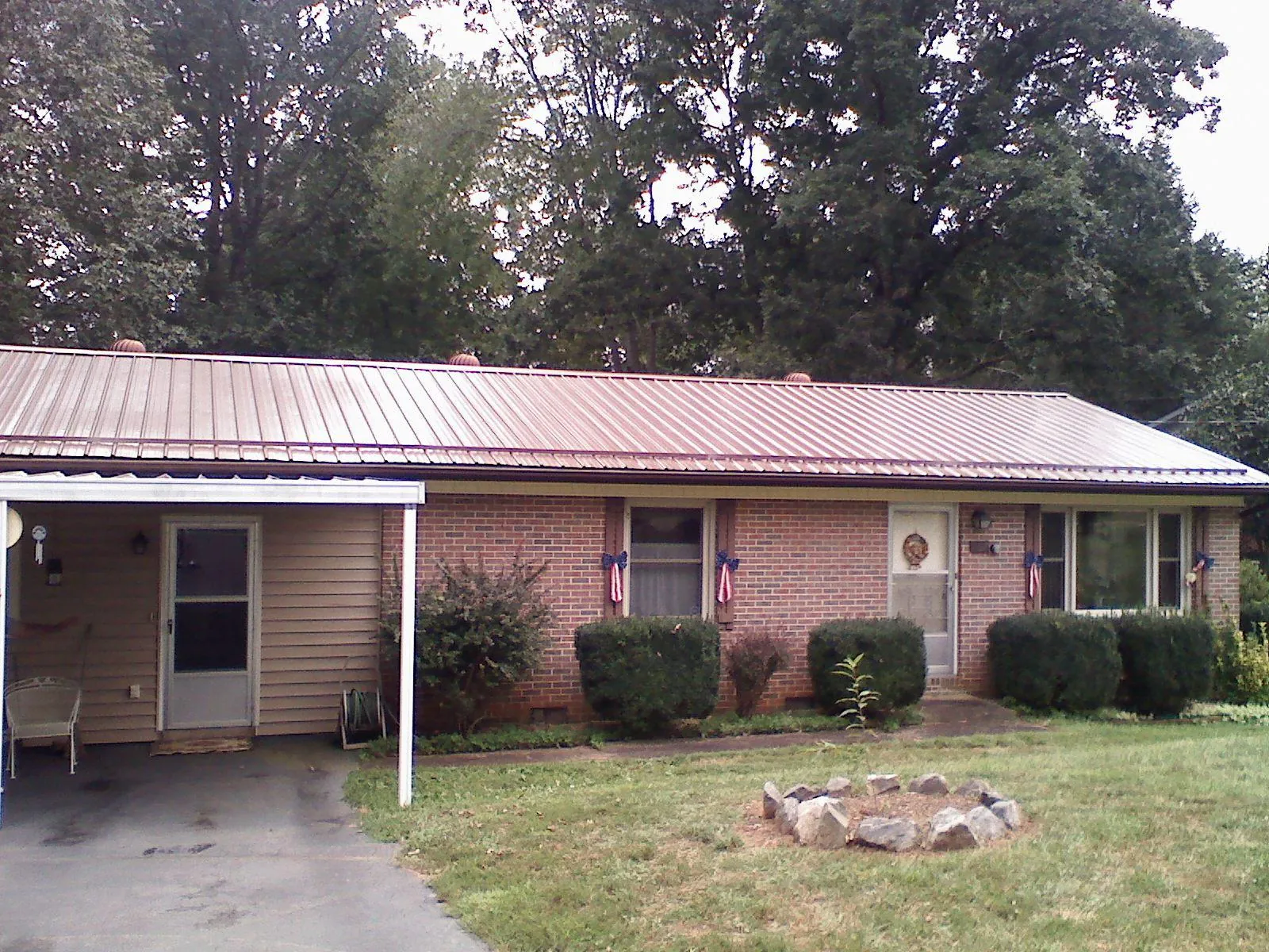 Bronze metal roof and carport on a brick ranch home — Roof Repair work by our crew in Universal City